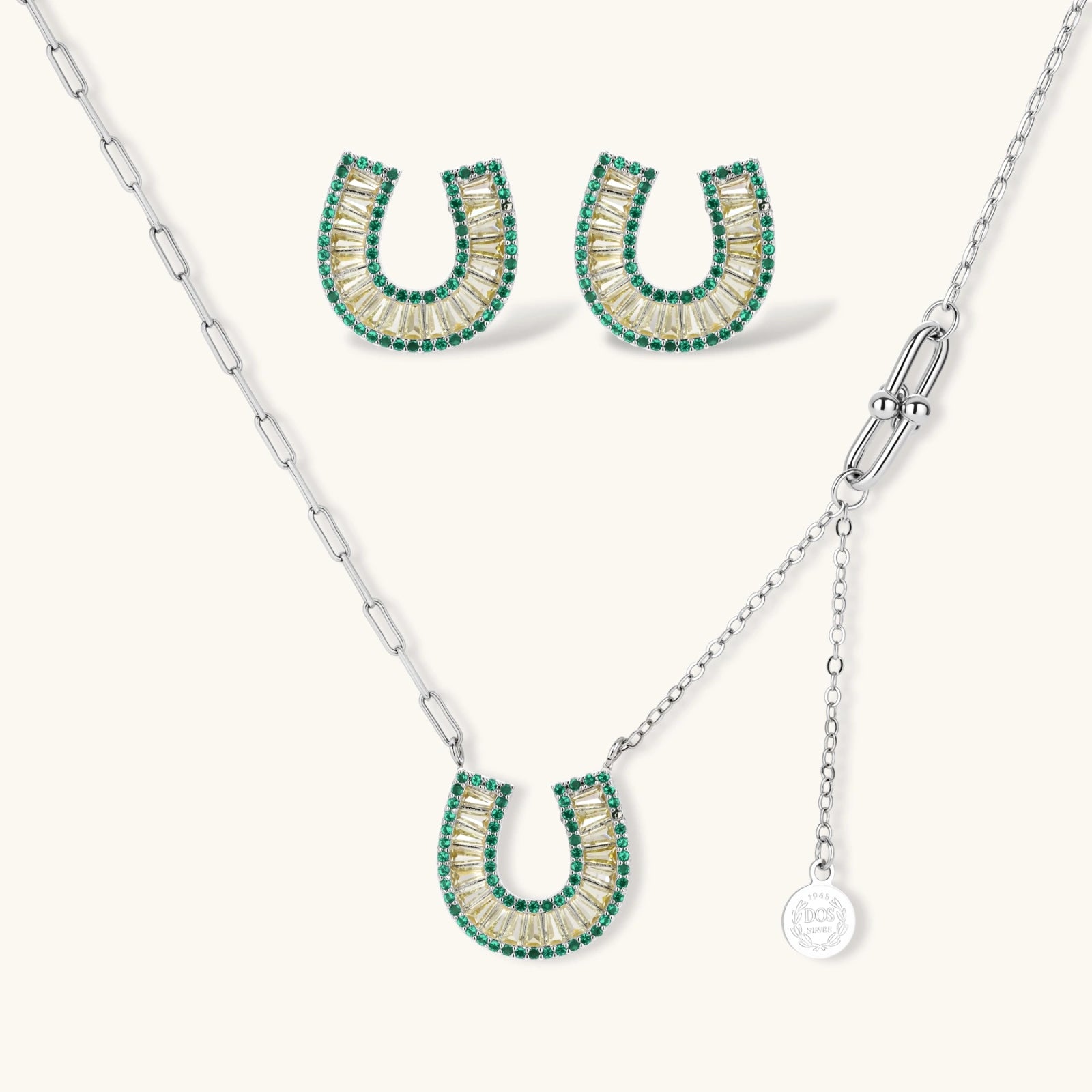 Geometric horseshoe-shaped jewelry set with radiating white zirconia center and jade-green border stones on white background.