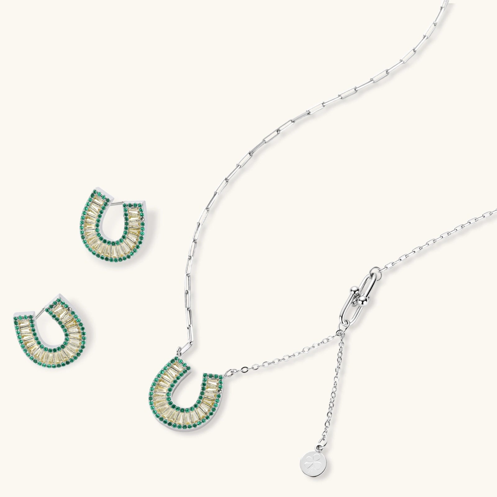 Geometric horseshoe-shaped jewelry set with radiating white zirconia center and jade-green border stones on white background.