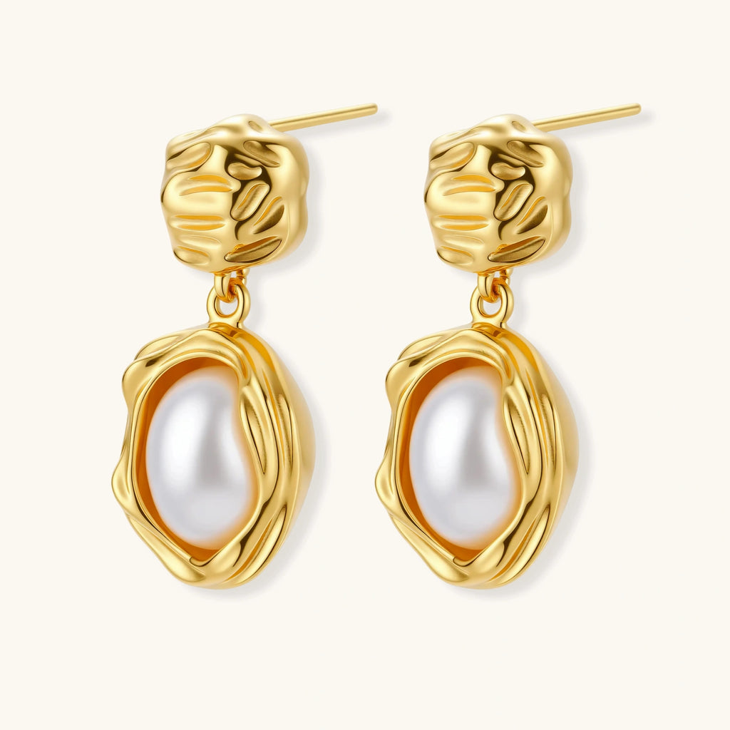 Gold-plated textured stud earrings with white freshwater pearl drops against cream background, showing organic rippled design
