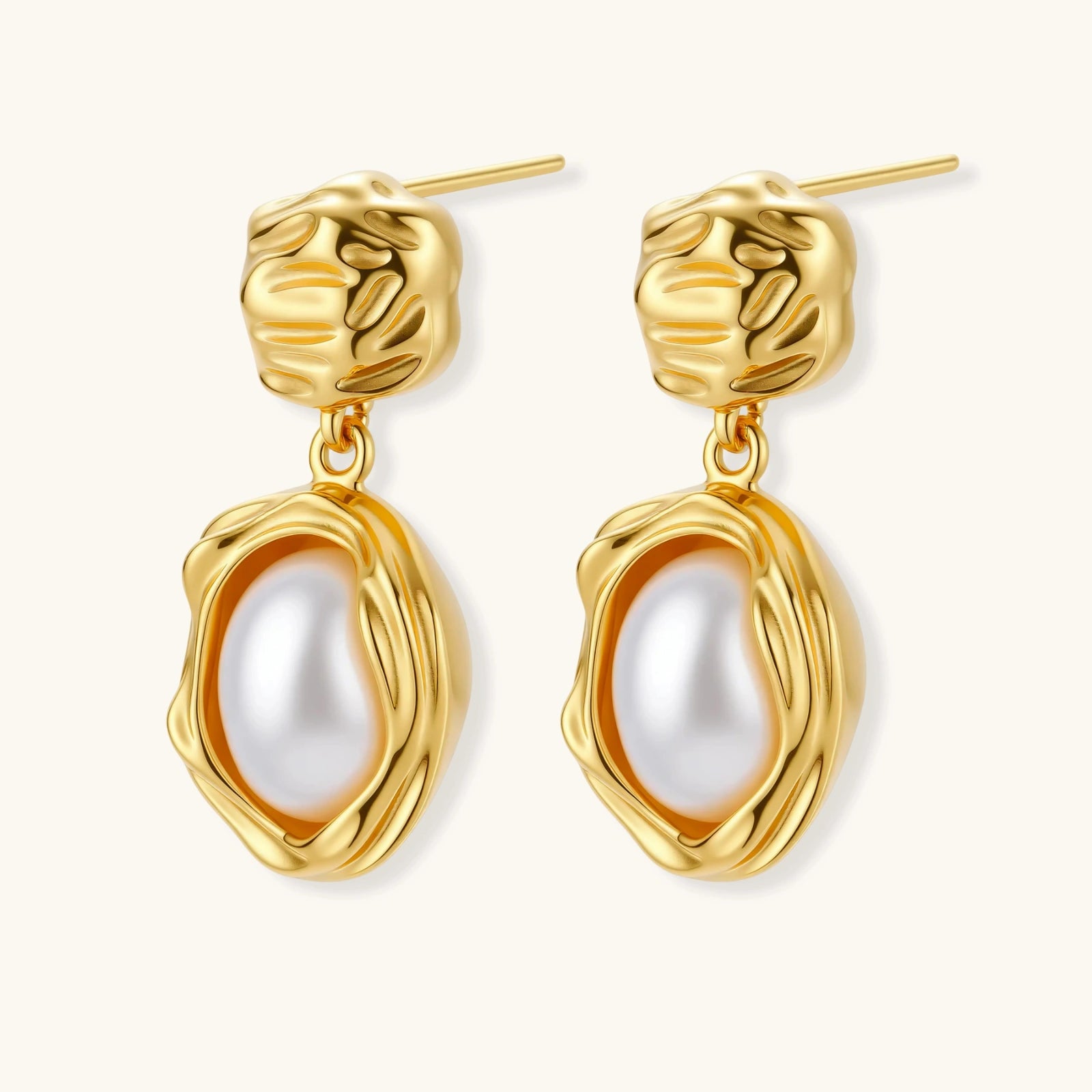 Gold-plated textured stud earrings with white freshwater pearl drops against cream background, showing organic rippled design