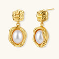 Gold-plated textured stud earrings with white freshwater pearl drops against cream background, showing organic rippled design