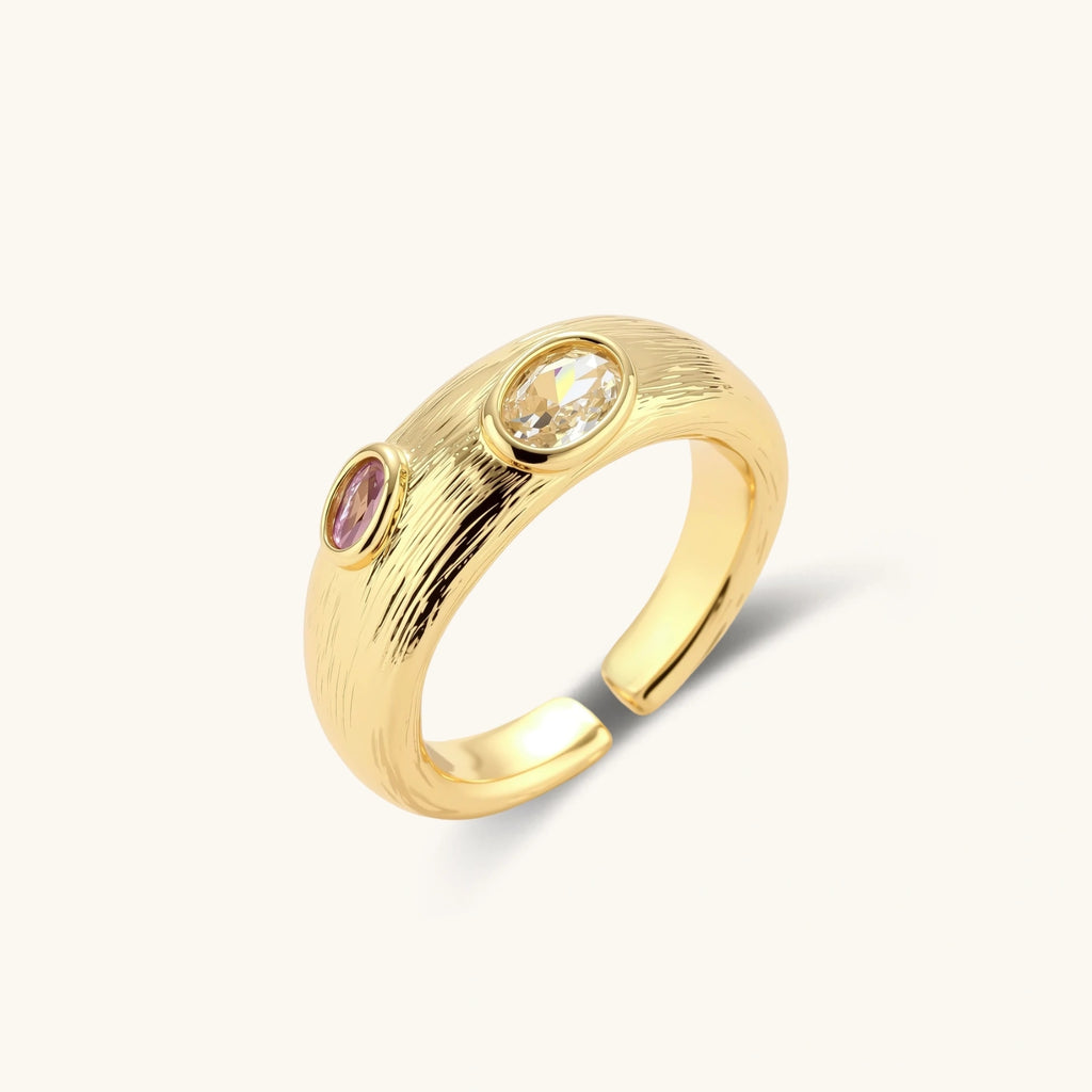 Gold-plated adjustable ring with textured band featuring champagne and purple gemstones on white background.