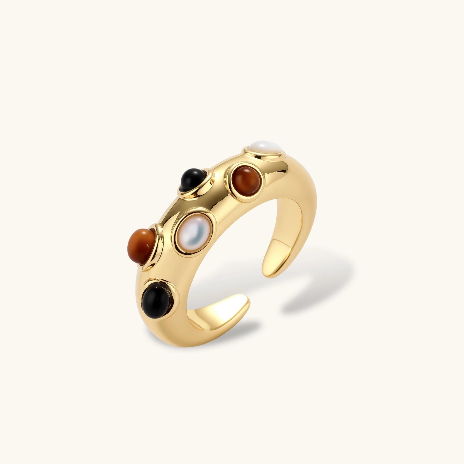 Gold-plated adjustable ring with white, amber, and black stones in organic bubble design on neutral background.