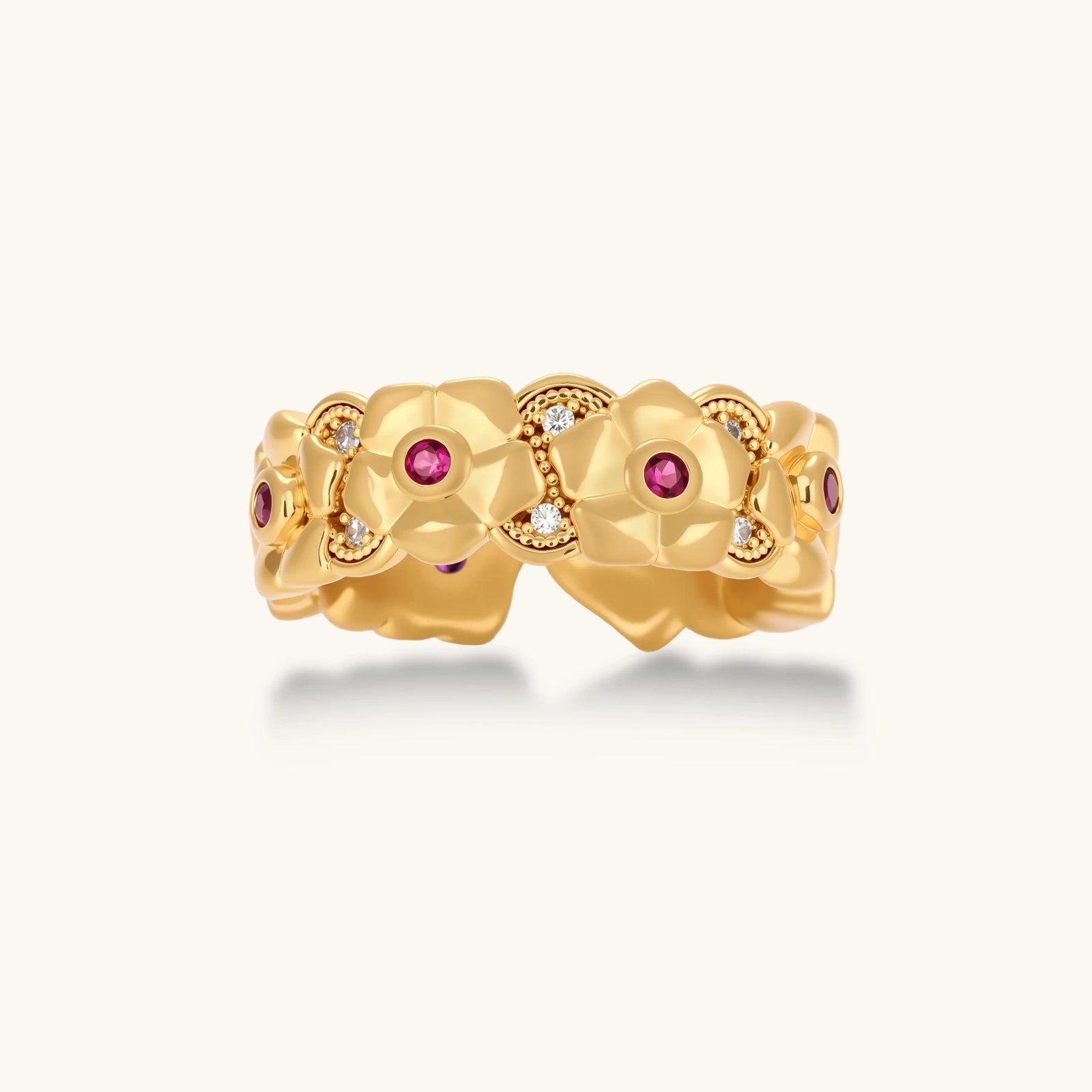 Adjustable gold-plated ring with burgundy zirconia centered flowers and crystal accents on cream background.