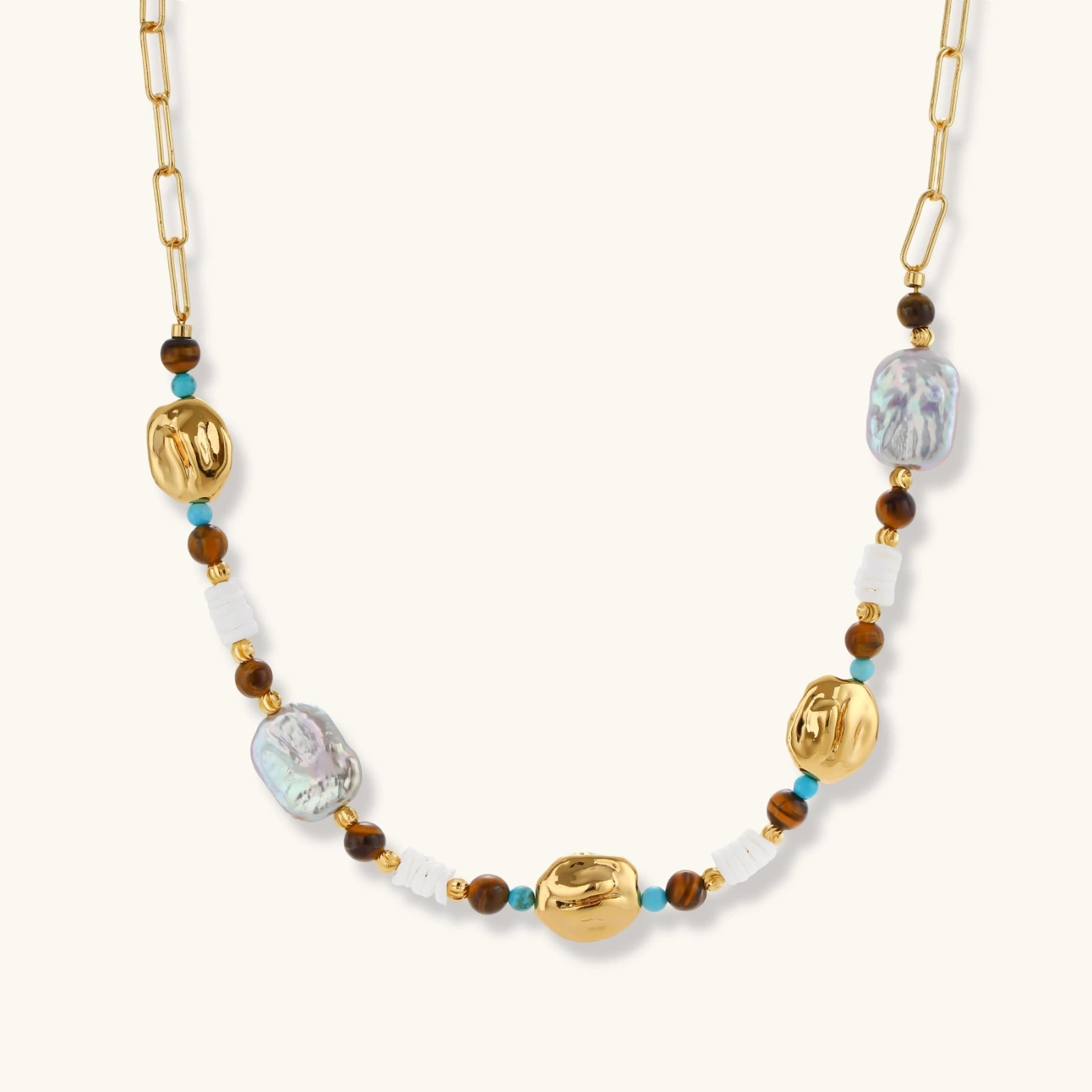 Gold-plated beaded necklace with iridescent baroque pearls, turquoise stones, and brown natural beads on neutral background.