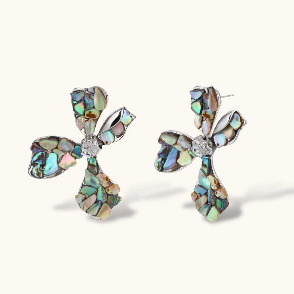 Cross-shaped stud earrings with iridescent abalone shell mosaic in blues and greens, silver-plated setting with crystal center