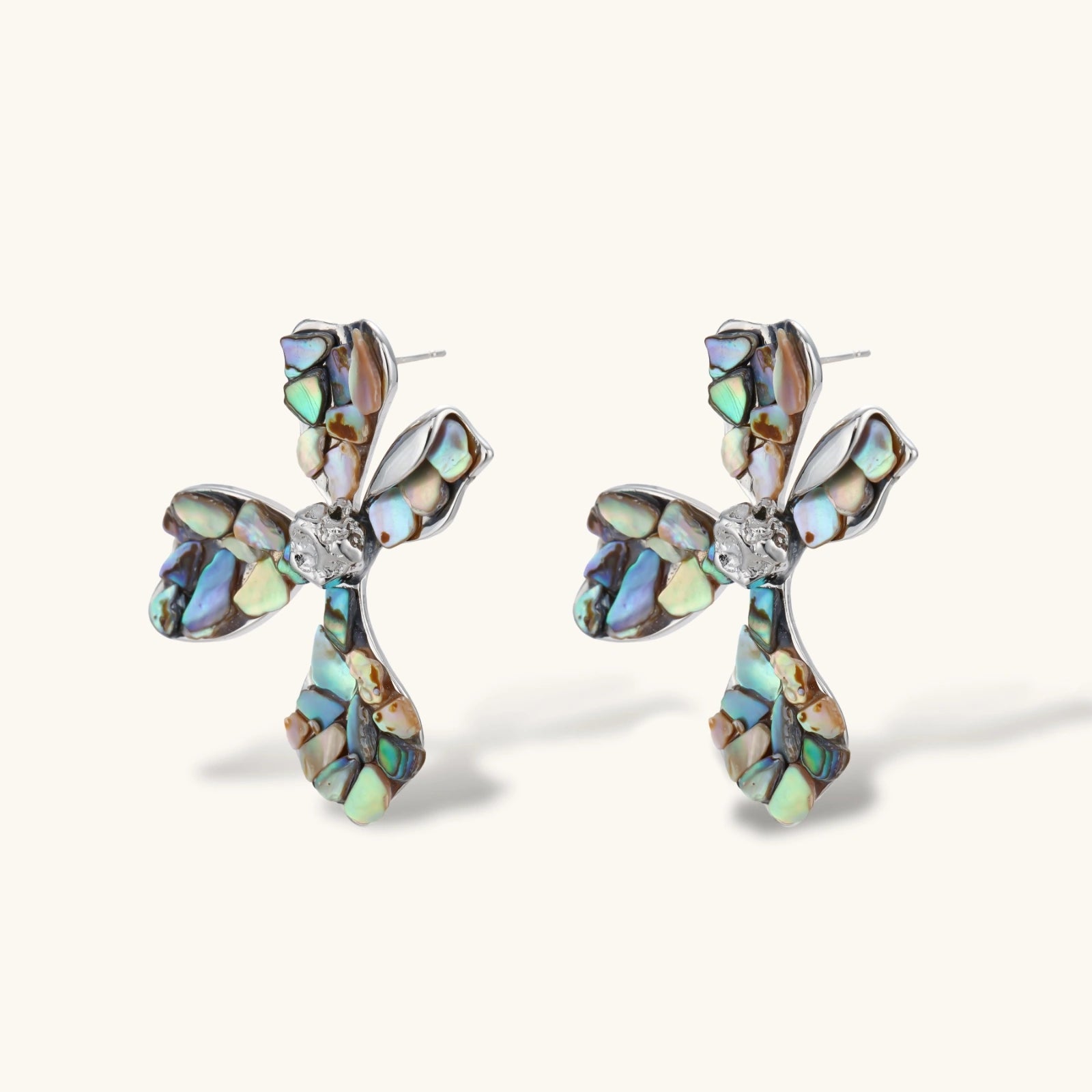 Cross-shaped stud earrings with iridescent abalone shell mosaic in blues and greens, silver-plated setting with crystal center