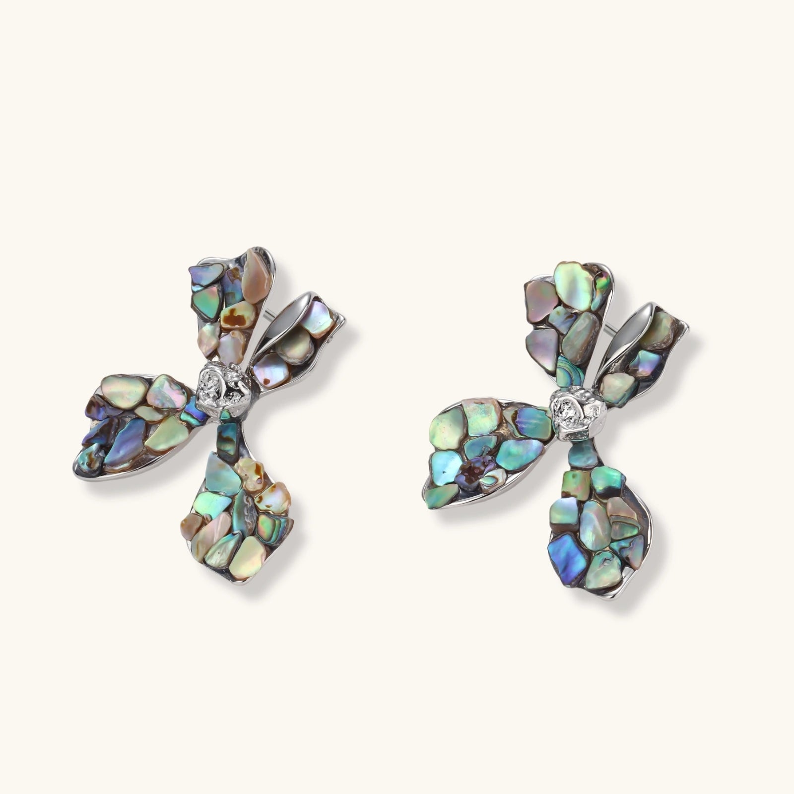 Cross-shaped stud earrings with iridescent abalone shell mosaic in blues and greens, silver-plated setting with crystal center